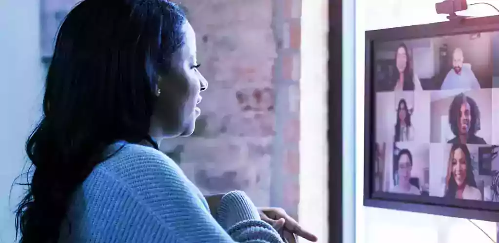 A woman in a meeting from her computer.