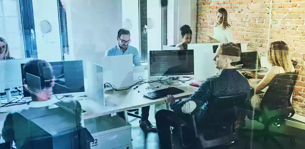 A group of workers in front of their computer.